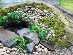 現場発生の玉石をランダムに積んだ土留め。自然素材は何でも使えます。
