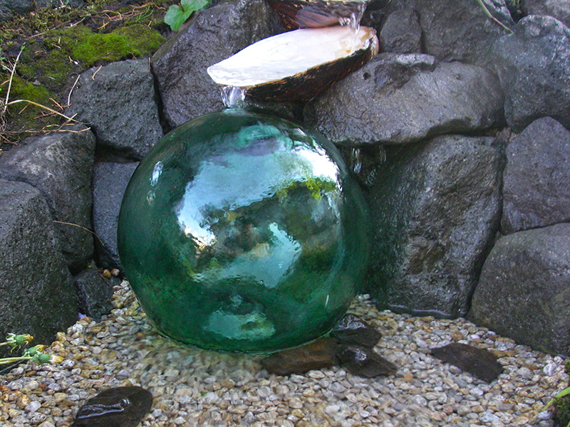 水はガラス玉を伝って球形に落ち、流れになる