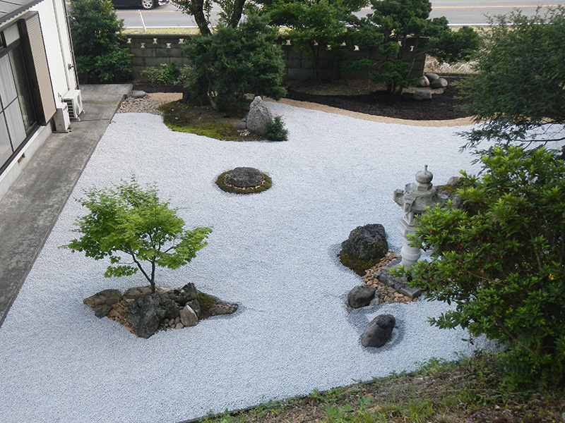 既存の石を組みなおした石組のある砂利敷きの庭