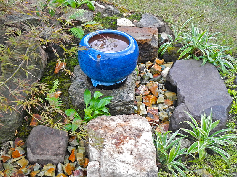 緑の芝に青い水鉢が映える