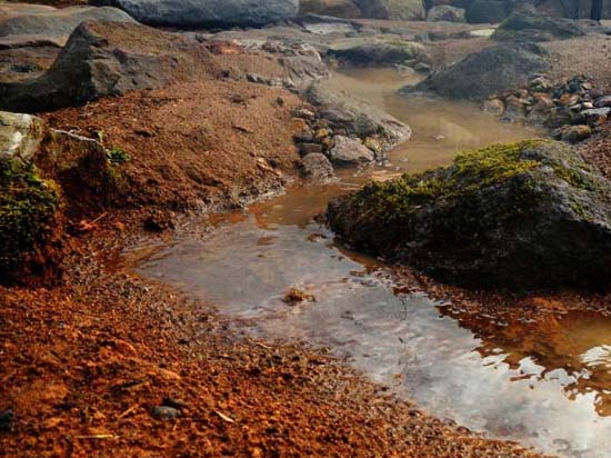小滝からの水が石畳の下から浸み出るように湧き、緩やかに赤土の上を流れていく